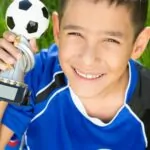 boy holding soccer trophy